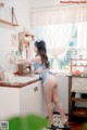 A woman standing in a kitchen next to a sink.