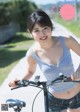 A woman riding a bike on a dirt road.