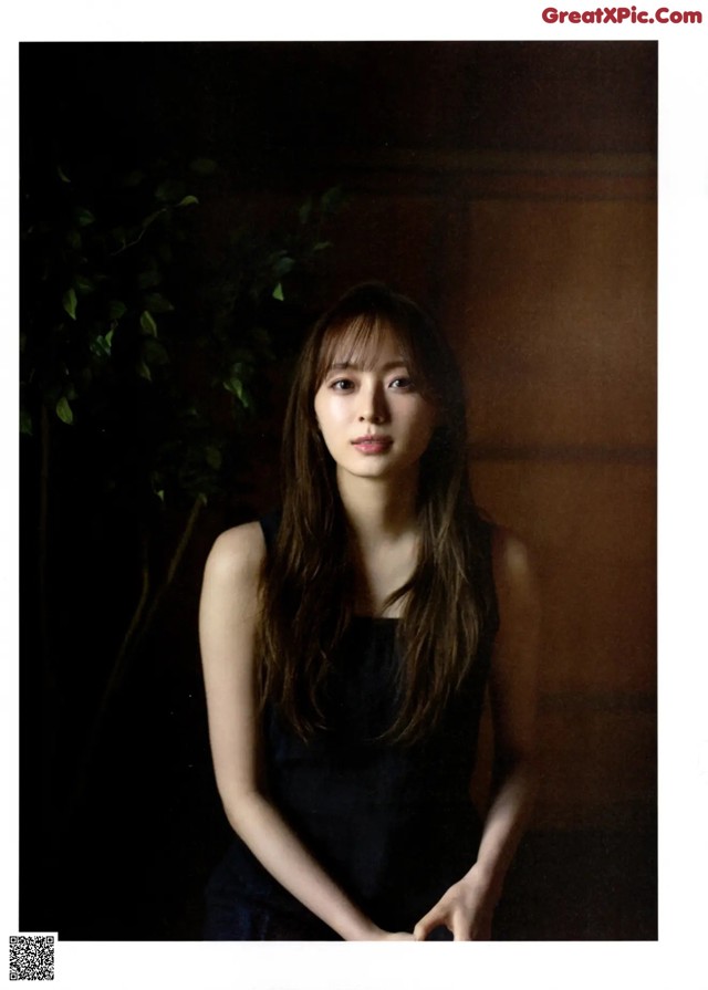 A woman in a black dress posing for a picture.