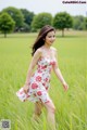 A woman in a white dress walking through a field.