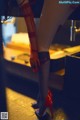 A woman in red stockings and high heels standing in a room.