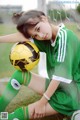 A woman in a soccer uniform holding a soccer ball.