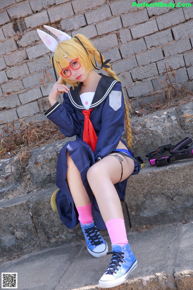 A woman in a school uniform sitting on some steps.