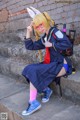 A woman in a school uniform sitting on some steps.