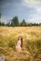 A woman standing in a field of tall grass.