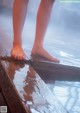 A person standing on a wooden platform in a hot spring.