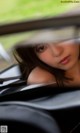 A woman is looking out the window of a car.