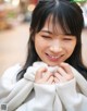 A woman in a white sweater smiles at the camera.