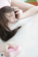 A woman in a pink dress is cleaning her hair.